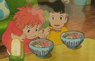 Anime gif. Very hungry, Ponyo reaches into a bowl of steaming ramen and pulls out a slice of meat, greedily putting it into her mouth as Sosuke watches in alarm. Ponyo’s mouth opens wide in pain as the meat burns her tongue.