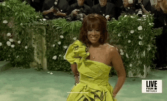 Met Gala 2024 gif. Gayle King posing for the cameras, in a chartreuse gown with big, bunched draping details.