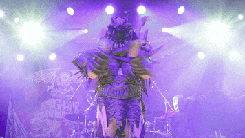 Celebrity gif. Member of Gwar slow claps sarcastically on stage, surrounded by two shining lights.