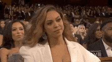 Celebrity gif. At an awards show, Beyonce nods in agreement and then smiles slightly while clapping her hands.
