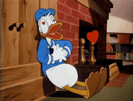 Cartoon gif. Donald Duck is leaning against a wall and he's giving himself resuscitation as hearts flood out from his chest and eyes.