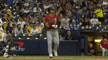 Sports gif. Christian Walker of the Arizona Diamondbacks throws his bat and jogs to first base in a casual way like he just hit it out of the park.
