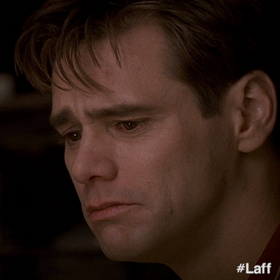 Movie gif. Eyes welling with tears, Jim Carrey as Truman in The Truman Show wipes a tear away and smiles emotionally.