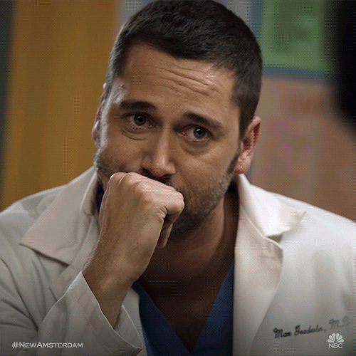 TV gif. Wearing a labcoat with his name on it, Ryan Eggold as Dr. Max from New Amsterdam rests his head on his hand and gives us a disappointed look.