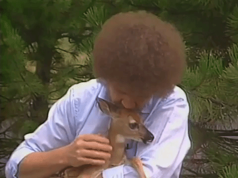 Gif of Bob Ross gently stroking and kissing a little baby deer
