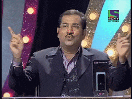 TV gif. A man on a game show celebrates by pointing his fingers in the air and shimmying while restraining his emotions. 