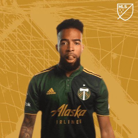 Sports gif. Soccer player Eryk Williamson shakes his fists in the air as he yells, “Let’s go!” He then throws his arm through the air in his excitement.