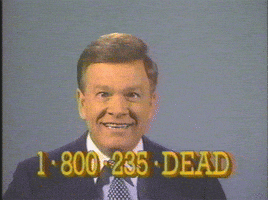 Video gif. Wink Martindale stares at the camera with dead, almost crossed eyes, and a weird smile. The image jitters like an old tv screen, but the man does not move or even blink. On the bottom, the text reads: “1-800-235-DEAD” like it’s an ad for a law practice. 