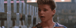 Movie gif. Corey Haim as Sam Emerson from The Lost Boys looks towards the left as a dazed smile spreads across his face.