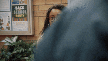 TV gif. Quinta Brunson as Janine on Abbott Elementary looks at us and twitches awkwardly then quickly shrugs.