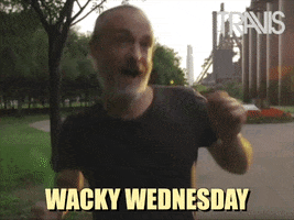 Video gif. Fran from the band Travis pumps his arms, dancing goofy, outside in a park plaza. Text, "Wacky Wednesday."