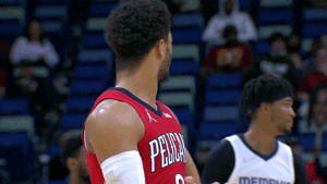 Sports gif. Josh Hart on the New Orleans Pelicans stands on the basketball court during a game, pointing at something with a look of complete surprise or confusion.  