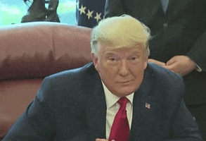 Political gif. Donald Trump rests his elbows on his desk and looks around aimlessly before shifting with a downward gaze.