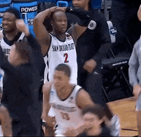 Sports gif. Basketball player on the SDSU Aztecs stands on the sidelines with his hands behind his head, scanning across the court, looking stressed and disappointed like he can't believe what just happened. 