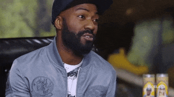 Celebrity gif. Desus Nice in a Yankees baseball cap falls back in a leather chair with amusement and surprise like he just figured out a clever joke. 