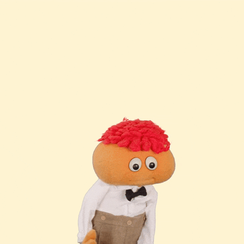 Video gif. Orange little puppet boy nervously looks around and holds his puppet hands together as he says, “Um um I just heh..heh..nevermind.”