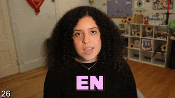 Video gif. Shalymar Rivera Gonzalez looks at us blankly and says, "En una programa de tecnologia media de media," while an image of a woman staring at a comptuer screen pops up. 