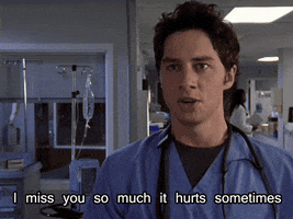 TV gif. Zach Braff as JD in Scrubs stands in a hospital hallway staring at someone as he proclaims, "I miss you so much it hurts sometimes."