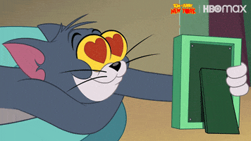Cartoon gif. Tom from Tom and Jerry looks with heart eyes at a picture frame, smiling in a dopey kind of way like he's lost in a daydream.
