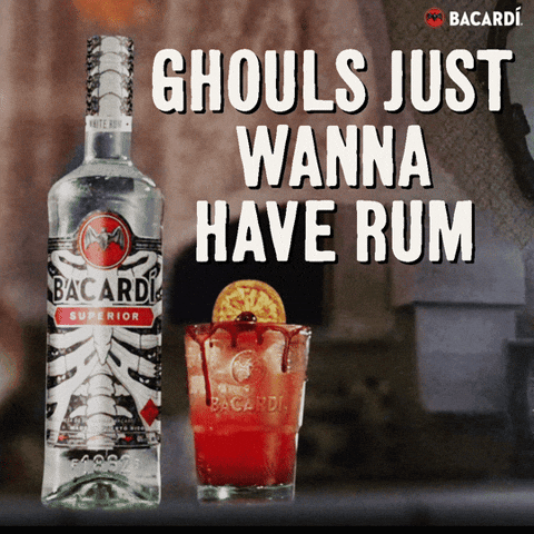 Sponsored gif. A Halloween-themed bottle of Bacardi and an orange cocktail on a countertop. Behind them, a curtain blows mysteriously and an old fashioned TV set shows spooky static. Text reads "GHOULS JUST WANT TO HAVE RUM."