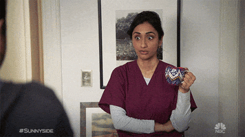 TV gif. Kiran Deol as Mallory in Sunnyside crosses her arms with a mug in one hand as she looks surprised, then rolls her eyes to the side with a cringe and a look of embarrassment.