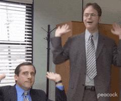 The Office gif. Steve Carell as Michael and Rainn Wilson as Dwight raise the roof as they pump their palms toward the ceiling and bob their heads rhythmically. 