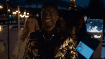TV gif. Samuel Arnold as Julien in Emily in Paris smiles proudly and claps.