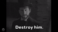 SNL gif. Parody of a period drama TV show. A man in a Victorian-era outfit, including a top hat and a dark coat displays a serious expression and intense gaze. The caption, "Destroy him." is shown at the bottom of the scene.