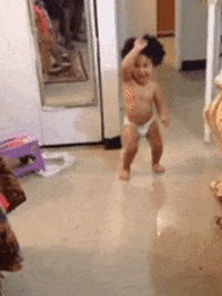 Video gif. A toddler wearing diapers does the samba as they shimmy towards us and back again.