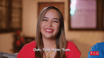 Reality TV gif. In a confessional, Annie Suwan from 90 Day Fiance smiles, her eyes closed. "Ooh. Yum yum yum," she says, which appears as text on screen. 