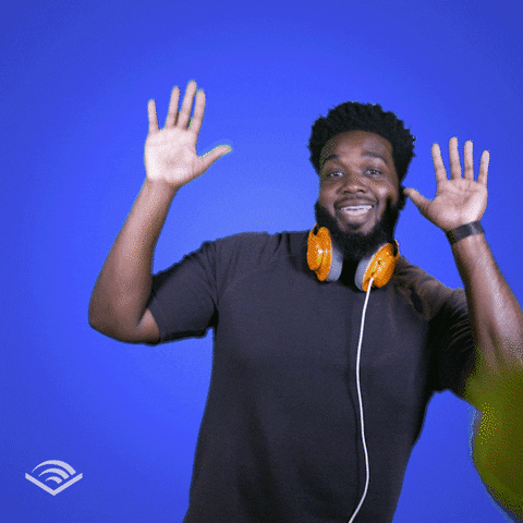 Video gif. Man wearing headphones around his neck smiles and dances like he's raising the roof, as yellow balloons are tossed in the air around him against a bright blue background. 