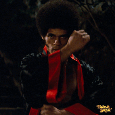 Movie gif. Jim Kelly as Williams in Enter the Dragon gazes as if trying to intimidate someone and does kung fu motions as his hands pass in front of him. 