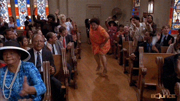 TV gif. A scene in a black church where everyone is dancing and vibing. A woman is in the center aisle and is sweeping the floor with her handkerchief, as they all shout with praises and blessings. 