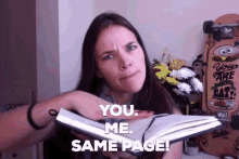 Video gif. A woman holding an open book with one hand. She uses the other hand to stroke the page and sends us a thumbs up. Text, "You. Me. Same page!"