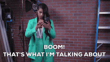 TV gif. Lilly Singh as host of A Little Late looks down at her green suit, shakes out her arms and says, "Boom! That's what I'm talking about."