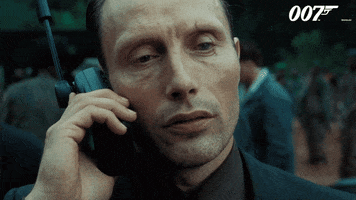 Movie gif. Close up of Mads Mikkelsen as Le Chiffre in Casino Royale, as he holds a walkie talkie and very seriously states, "Just do it."