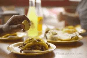 Ad gif. Hand squeezes a lemon on top of tacos next to plates of condiments and Jarritos soda bottles. The bottom right text reads, "Hashtag Respect The Taco."