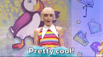 SNL gif. Wearing a short blond wig and a rainbow tank top, Chloe Fineman shakes both pointer fingers in the air and says, “Pretty cool!”