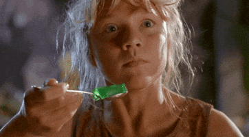 Movie gif. In a quickly glitching video, Ariana Richards as Lex in Jurassic Park holds a shaking spoonful of green jello.