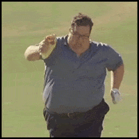 Video gif. A heavier man struggles to run down a field with what looks like a  burrito in his hand.