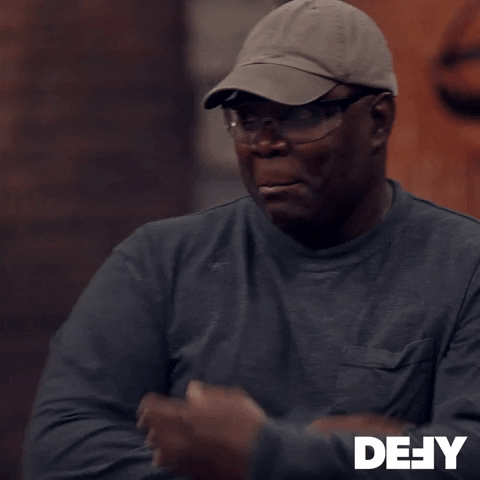 TV gif. A man on Forged in Fire looks concerned as he crosses his arms and puts one hand to his face.