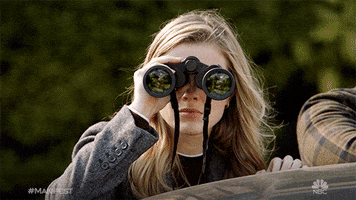 TV gif. A blonde woman from Manifest looks at us through binoculars.