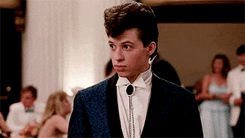 Movie gif. John Cryer as Duckie in "Pretty in Pink" at the school dance points to himself in disbelief and asks, "Moi?"; Kristy Swanson as Duckette smiles and nods, and Duckie looks back at us.