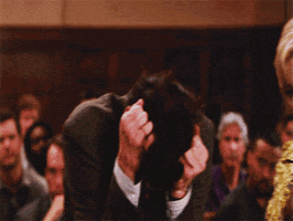 Movie gif. Jim Carrey as Fletcher from Liar Liar lifts his head up while gripping his hair and gives a feral yell.