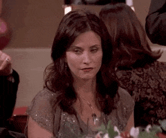 Friends gif. Courtney Cox as Monica seated at a dinner table gives a huge eye roll at someone off screen.