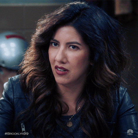 TV gif. Stephanie Beatriz as Rosa in Brooklyn Nine Nine blinks hard and glances at us, looking disgusted, with her mouth slightly open.