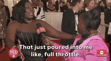 Oscars 2024 GIF. Danielle Brooks on the red carpet emphasizes the visual interpretation, sweeping her arms like a wave back on to herself. Text, “That just poured into me, like, full throttle.”