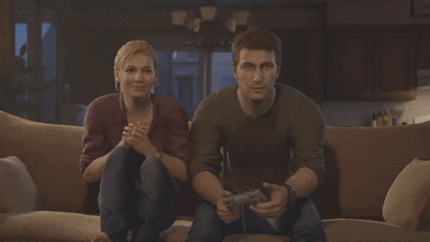 Nathan and Elena sitting on a couch playing video games