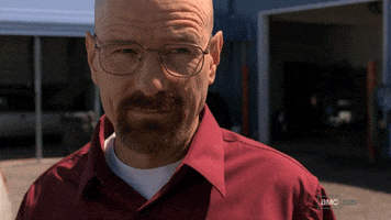 TV gif. Bryan Cranston as Walter White in Breaking Bad mean mugs, winking humorlessly.