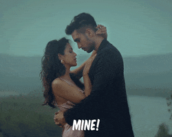 Video gif. A man and woman hold each other standing in the mist as they put their foreheads together, her hair blowing in the breeze. Text, "Mine!"